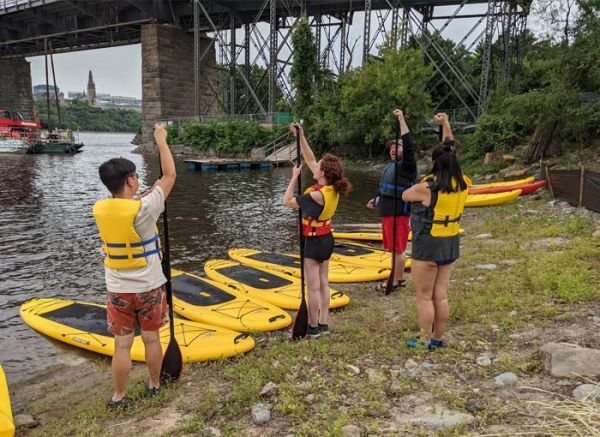 Paddle Board instructor demonstrates how to measure the paddle